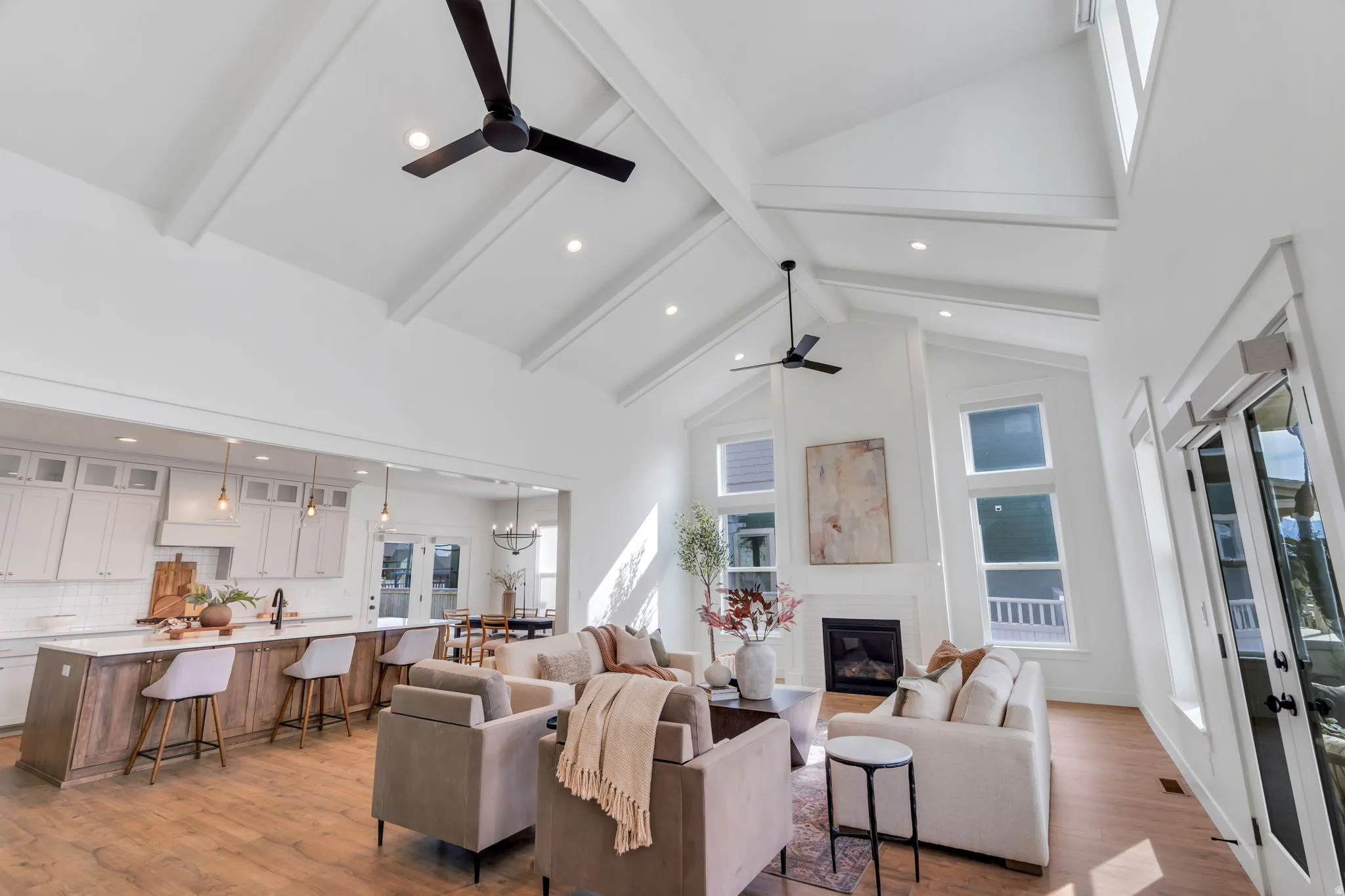 Living area with dark wood-style flooring, vaulted ceiling, a glass covered fireplace, recessed lighting, and a ceiling fan