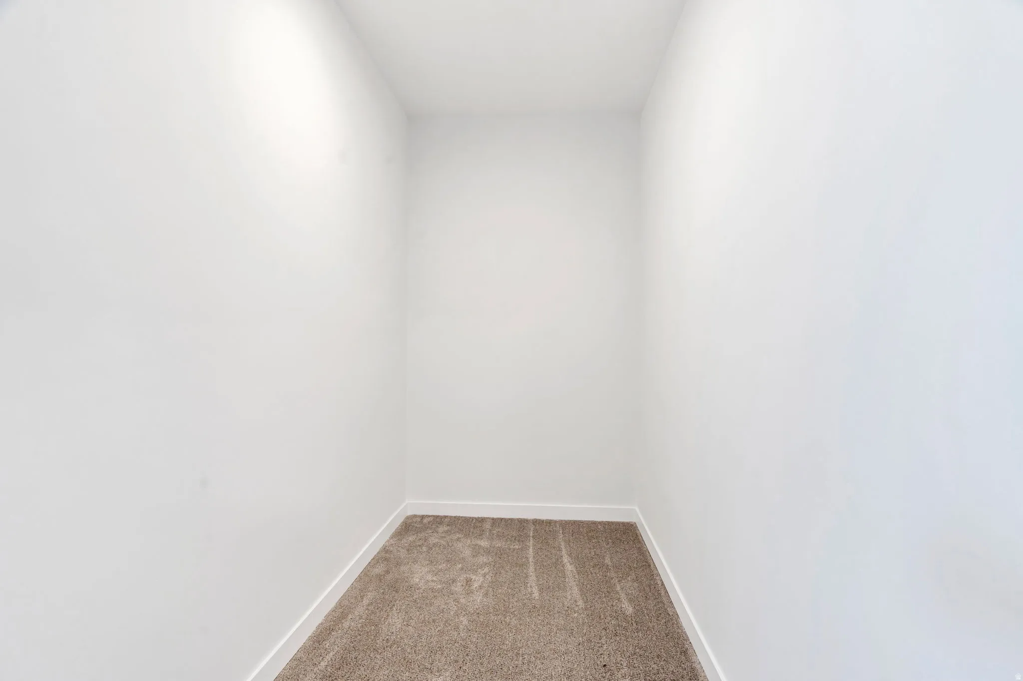 Spare room featuring carpet floors and baseboards