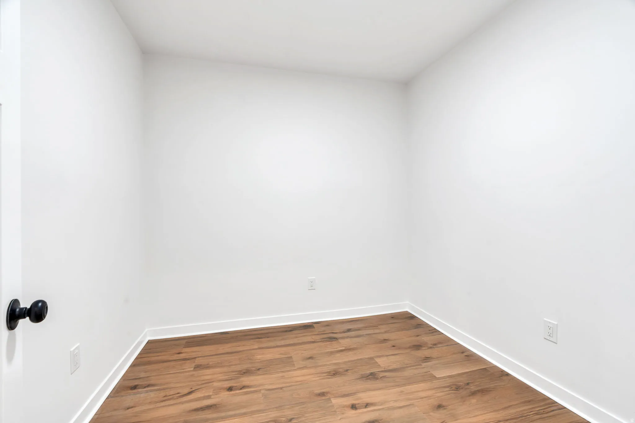 Unfurnished room featuring dark wood finished floors and baseboards
