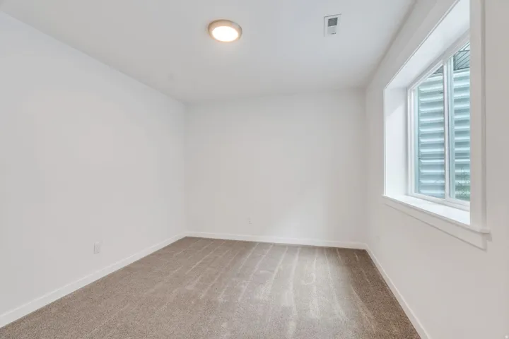 Carpeted empty room with baseboards