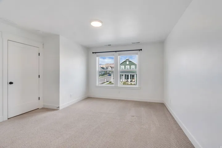 Spare room featuring light carpet and baseboards