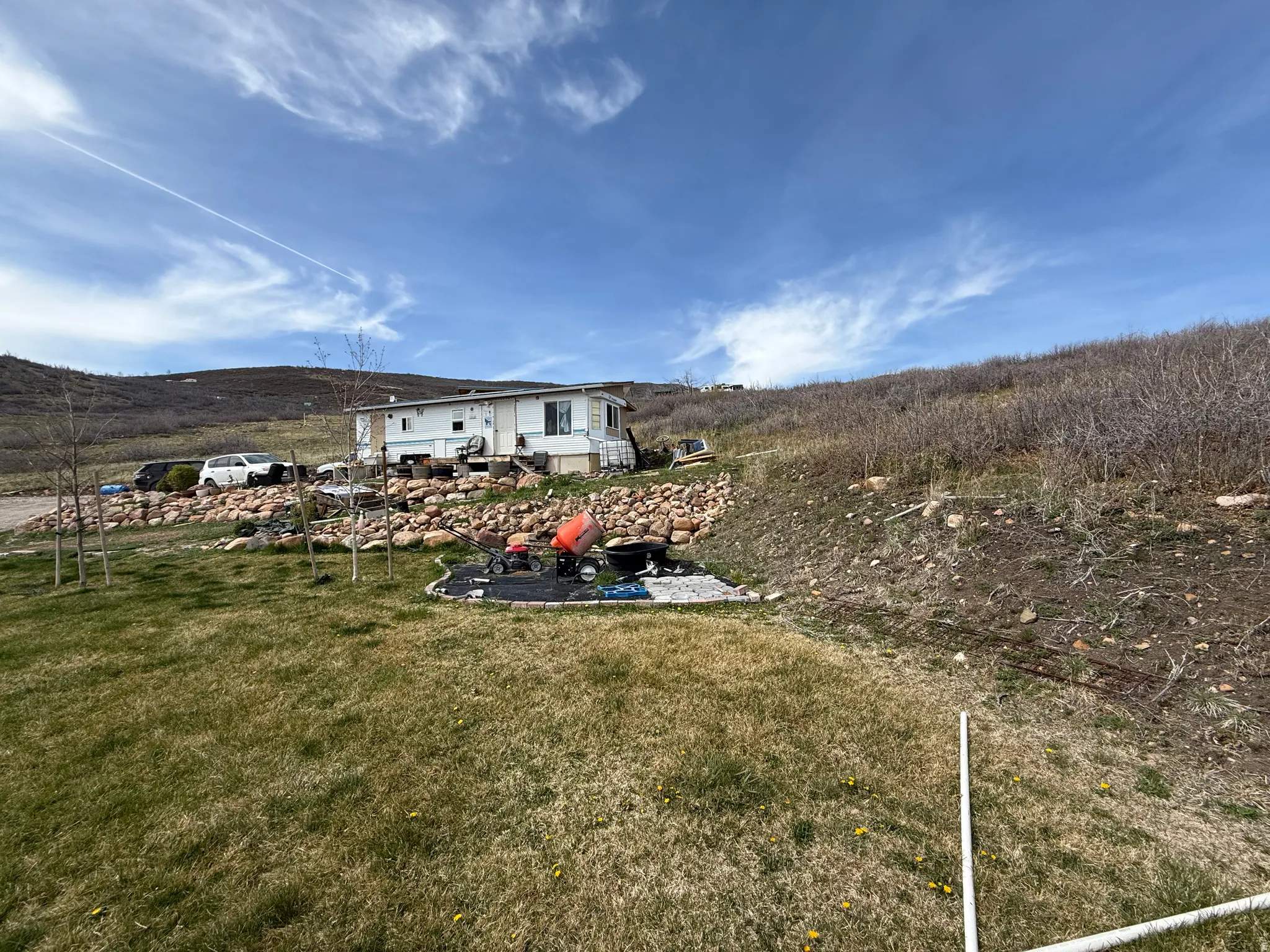 View of green lawn with a patio area and a mountain view