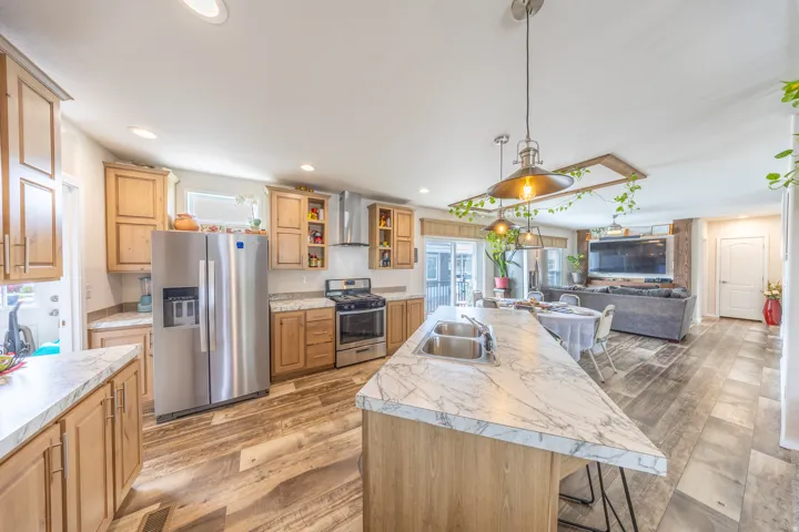 Kitchen featuring stainless steel appliances, light wood-style floors, a breakfast bar area, and open floor plan