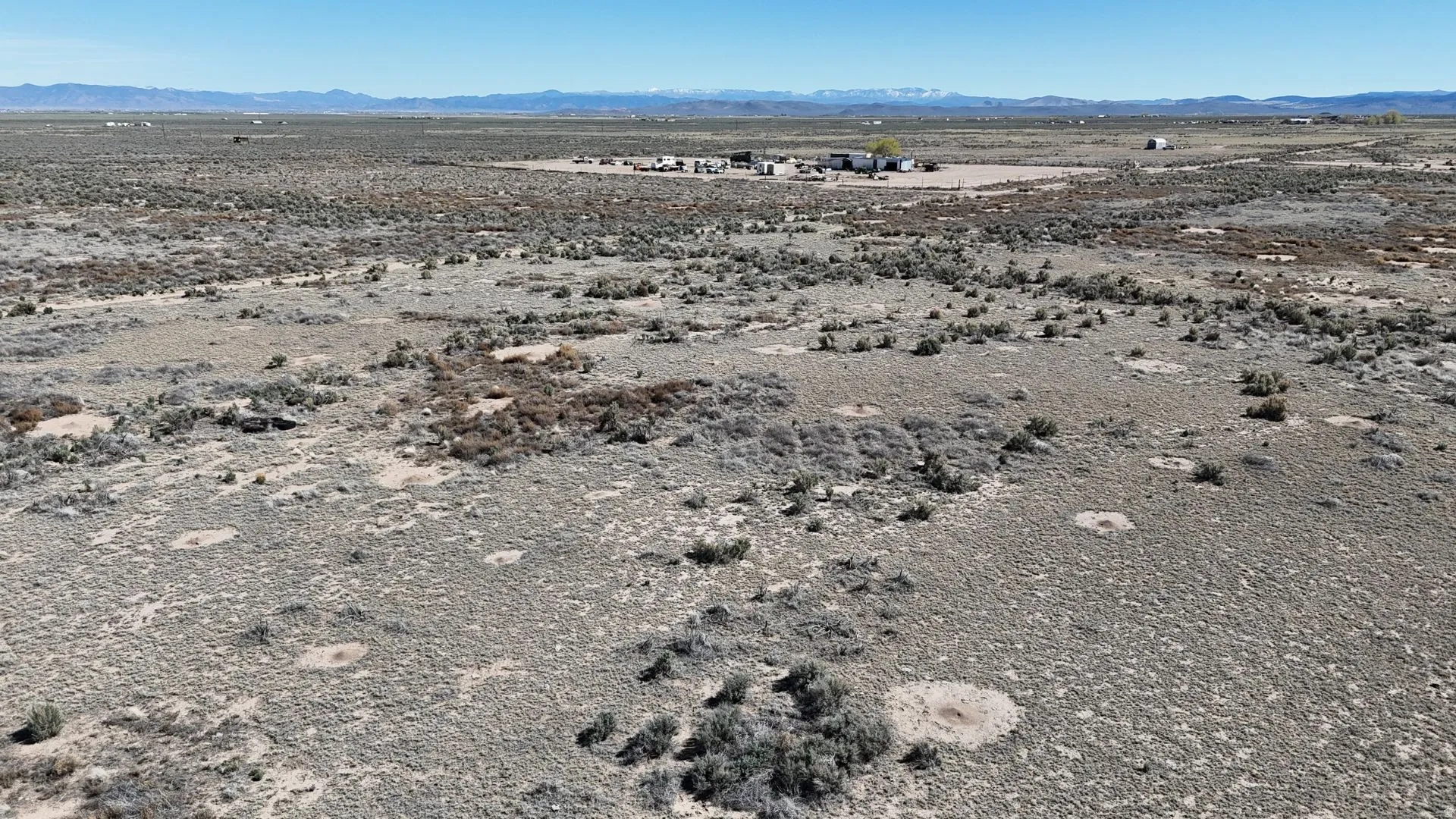 Aerial view of sparsely populated area featuring a mountainous background and a desert landscape