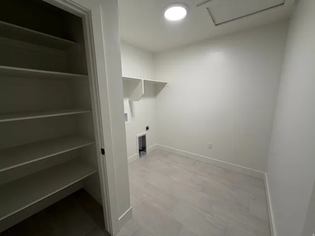 Dedicated utility space featuring a neutral color palette, recessed ceiling lighting, and light-toned tile flooring