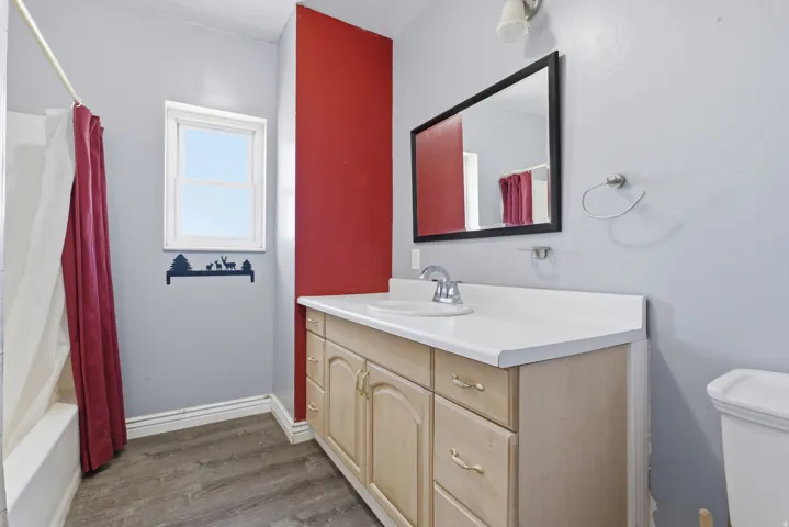 Bathroom featuring a light wood-finish vanity with a white countertop and integrated sink