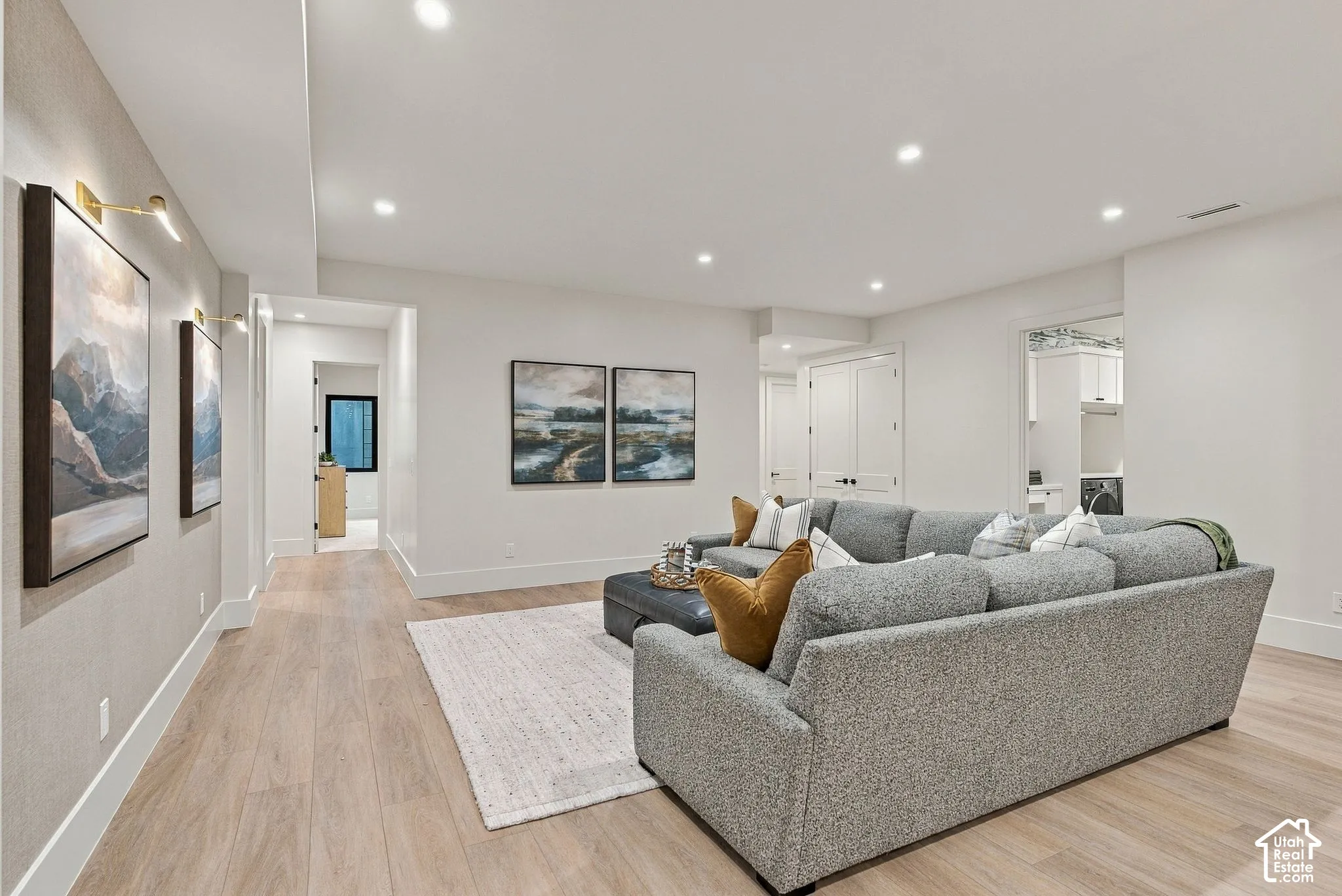 Wood-finish flooring, recessed lighting, and wall-mounted light fixtures