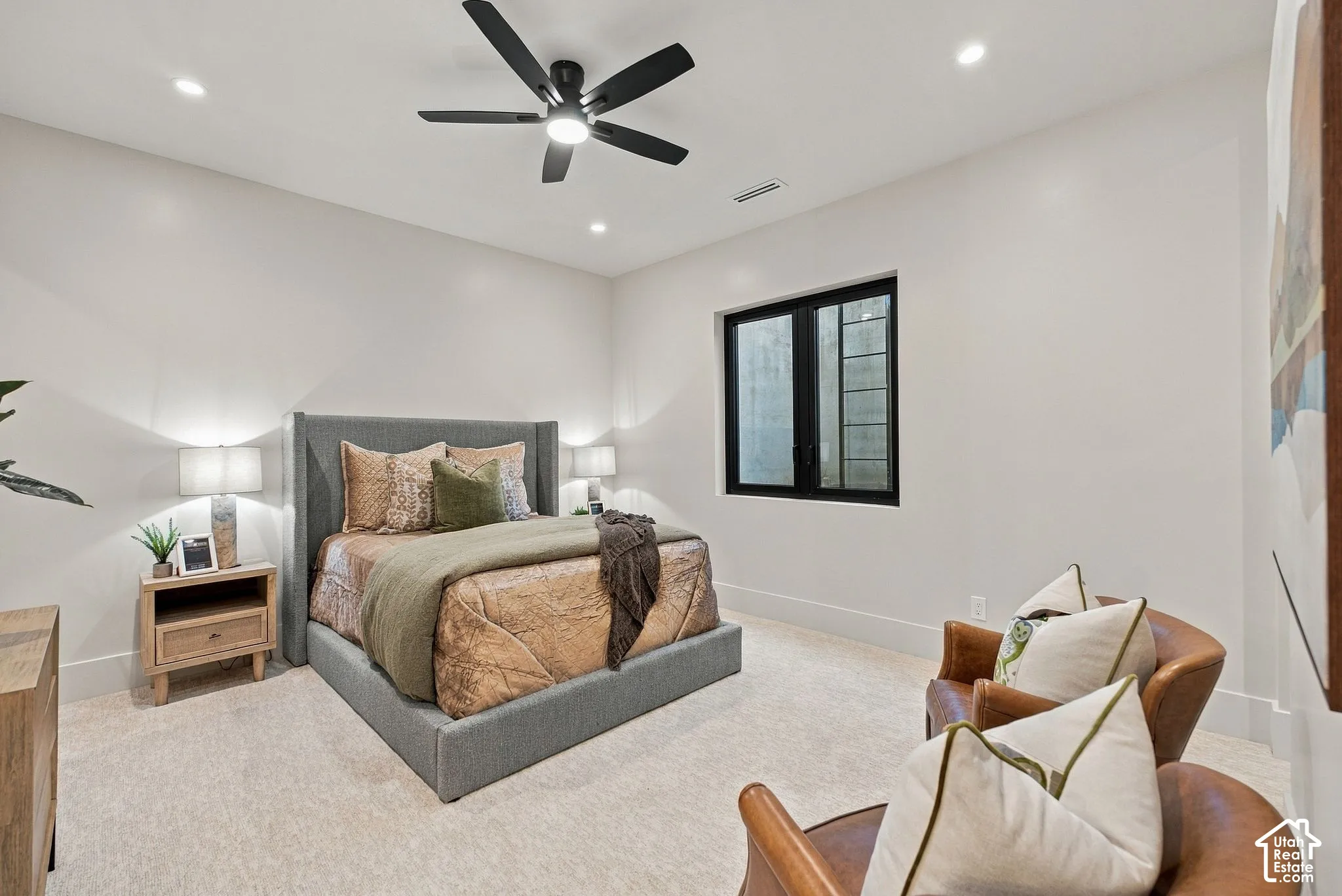 Bedroom featuring neutral wall-to-wall carpeting, recessed ceiling lighting, a dark-finish ceiling fan, and a window with a black frame