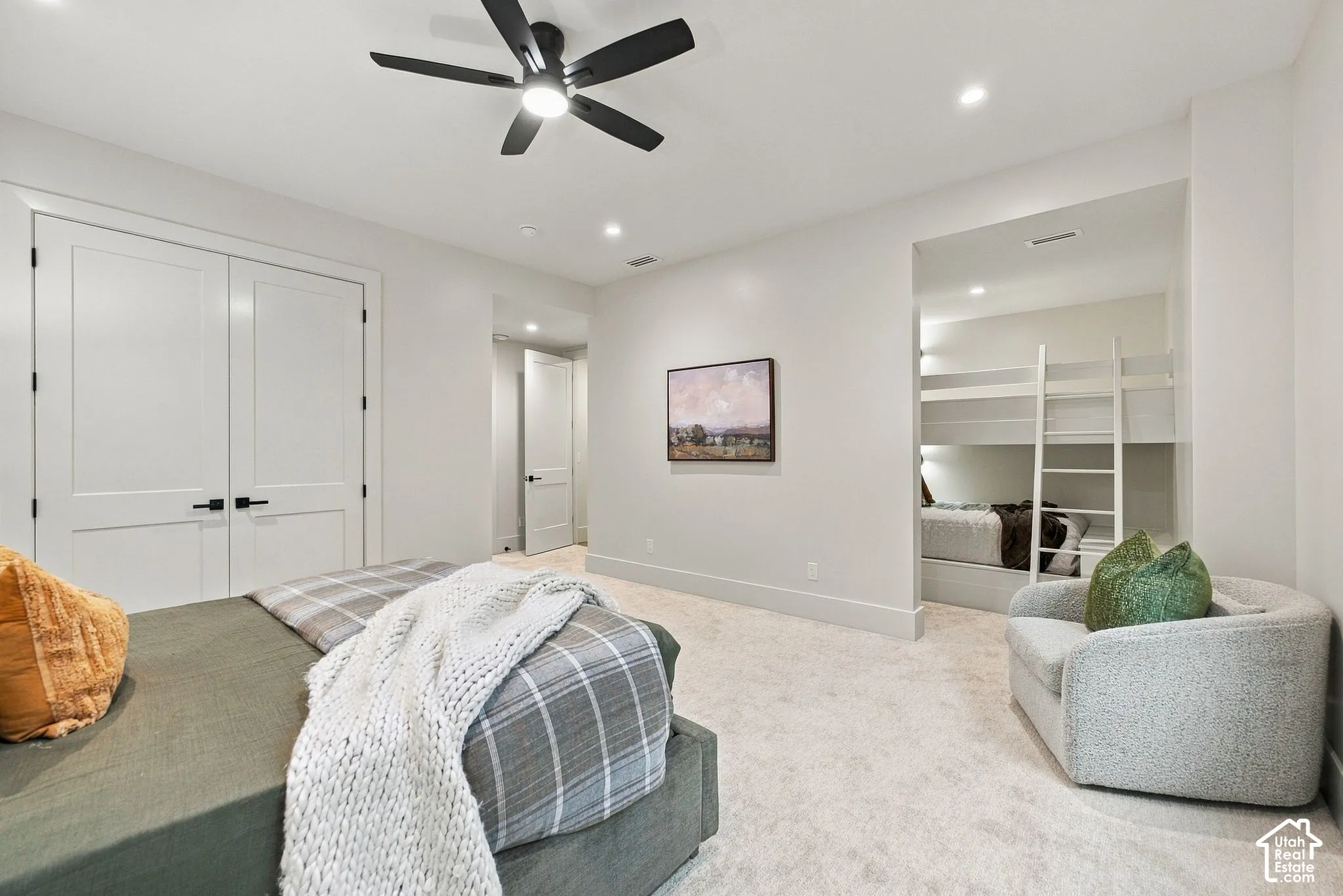 Spacious bedroom featuring recessed lighting, a modern ceiling fan, double-door closet, and a built-in recessed sleeping alcove