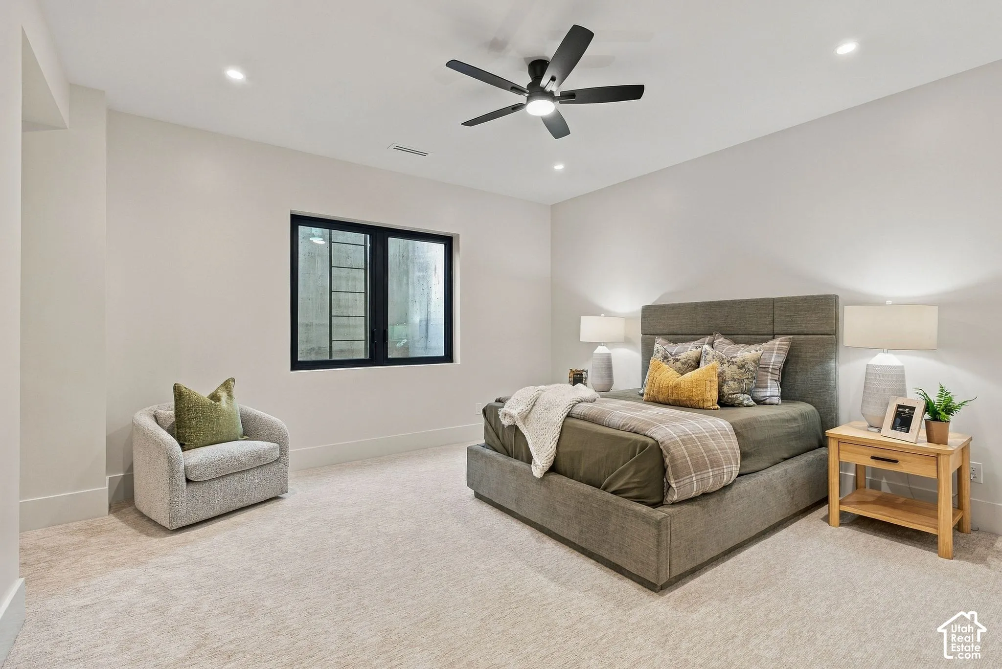 Neutral-toned interior featuring recessed lighting, a modern ceiling fan with an integrated light fixture, and a window with a black frame