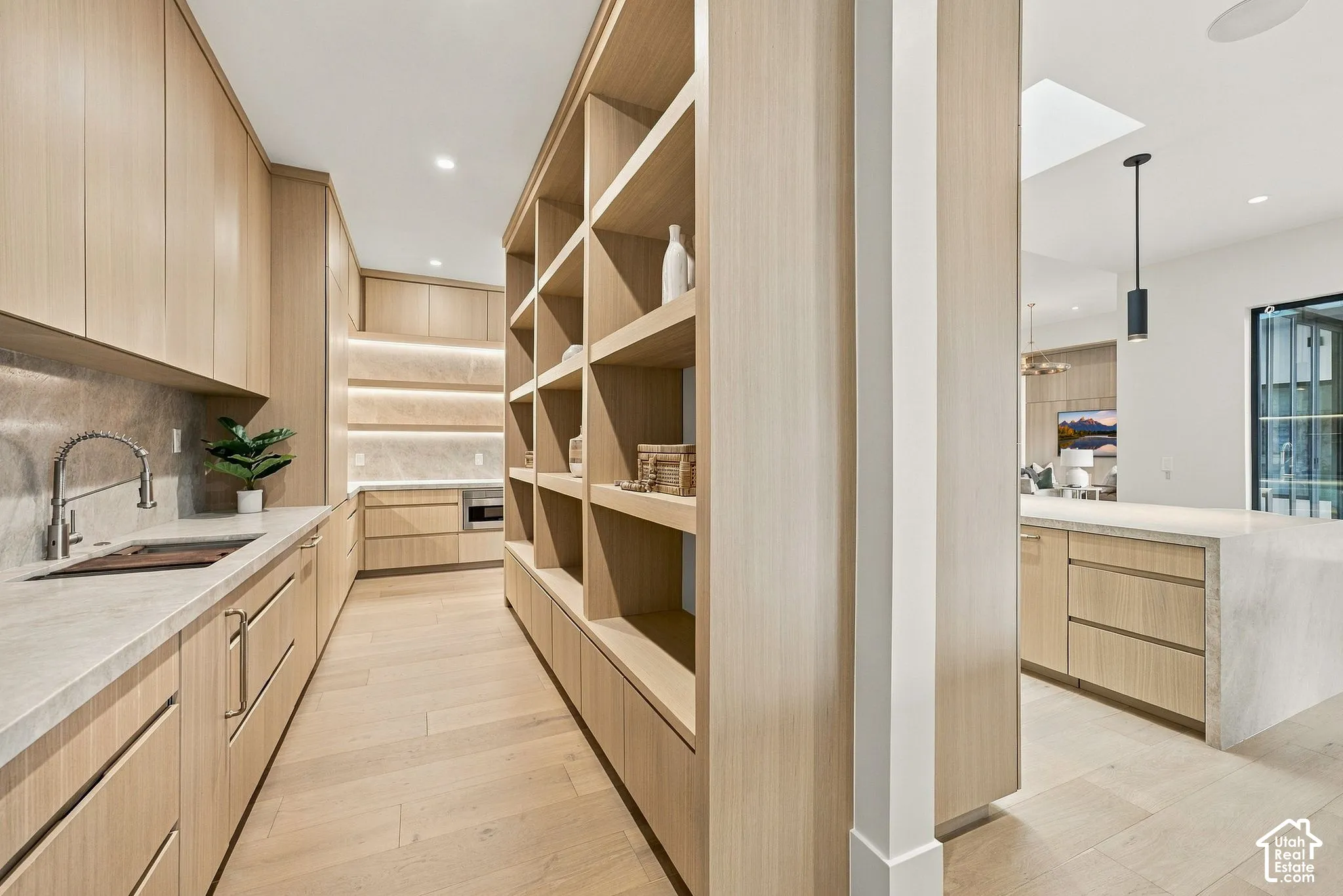 Gand butlers panty with tons of floor to ceiling closed and open storage cabinetry.  Features a grocery door from the garage for added convenience. Complete with a workstation sink,  pebble ice machine, dishwasher, and a Thermidor freezer. Custom white oa