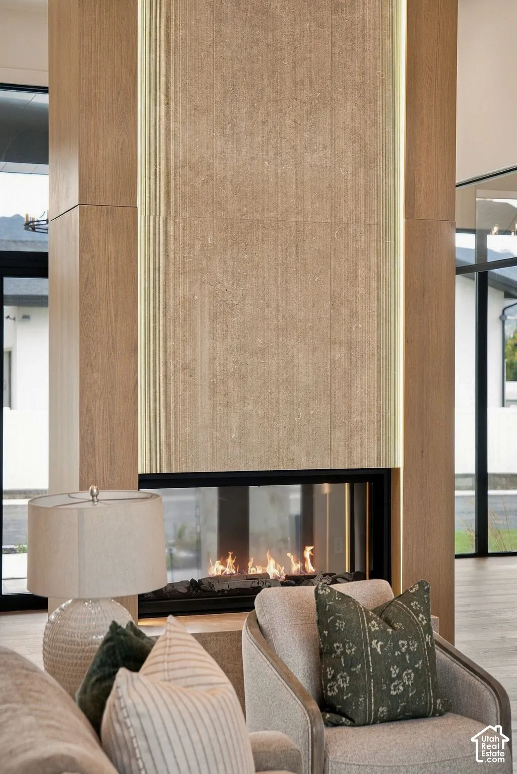 Floor-to-ceiling fireplace feature with linear gas insert, stone tile surround, integrated vertical accent lighting, and wood-finish paneling