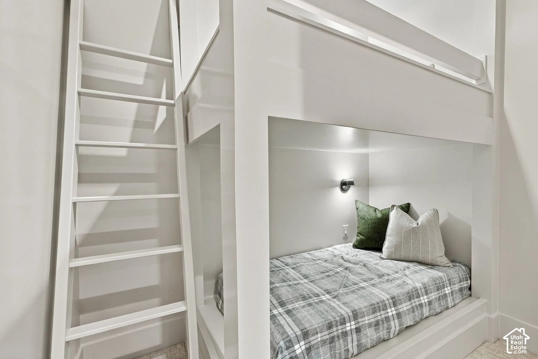 Built-in bunk beds featuring a custom white timber frame, an integrated vertical ladder, and a dedicated wall-mounted spotlight