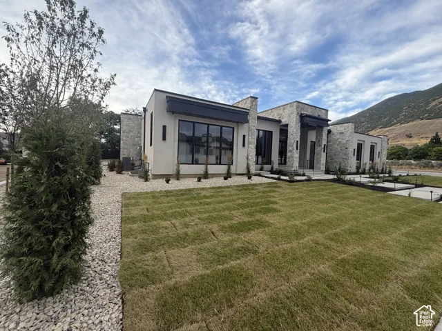 Modern facade featuring stone accents, stucco finishes, and dark window frames