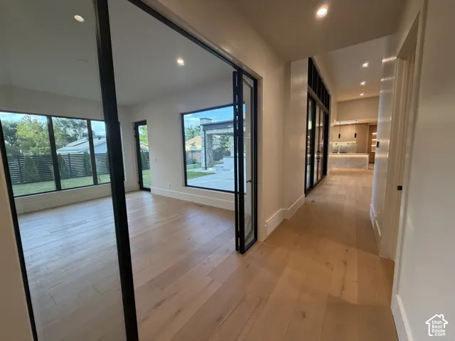 View of flex room and view to kitchen. Light wood-finish flooring throughout, complemented by recessed lighting