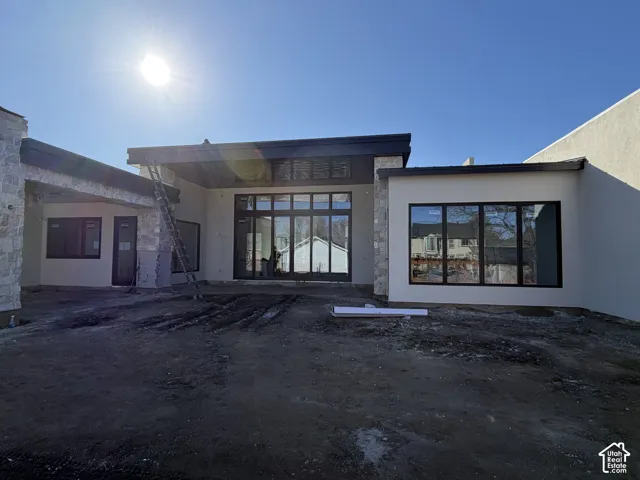 View of the back of property. Large covered patio, massive walkout sliding door flush with floor into the large living room and flex room
