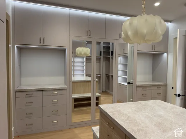 Custom built-in cabinetry with integrated lighting and stone countertops, full length mirror and a safe