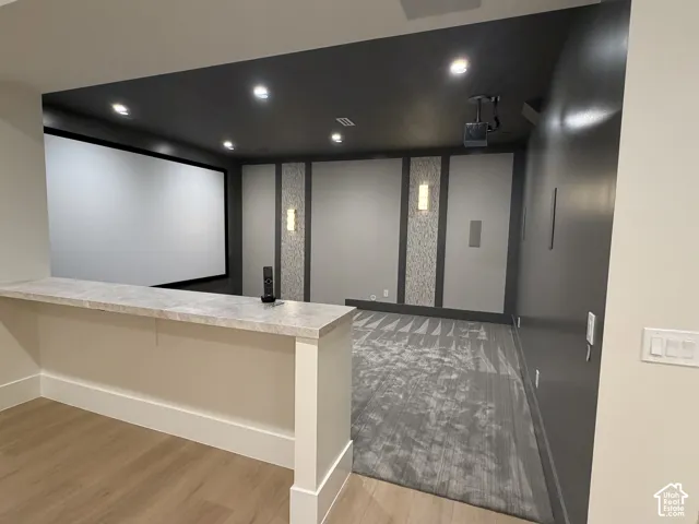 Dedicated entertainment space featuring a large projection screen, recessed lighting, and a mounted projector