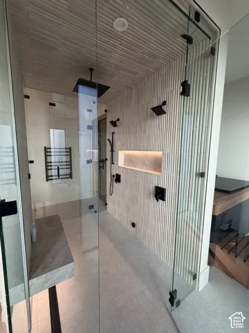 Spacious walk-in shower featuring glass enclosures and custom tile