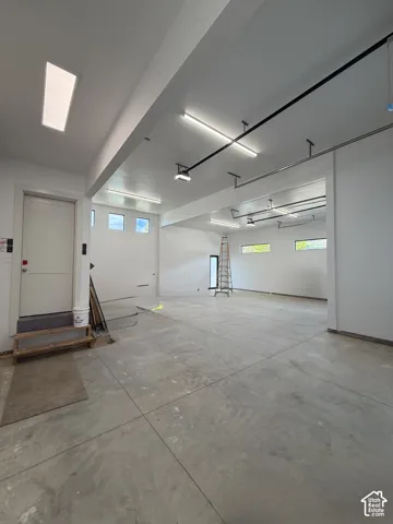 Spacious interior with concrete flooring and white painted walls