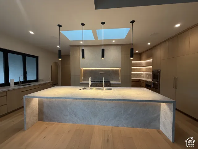 Waterfall Taj Mahal island with integrated undershelf lighting and dual workstation sinks. Thermidor appliances