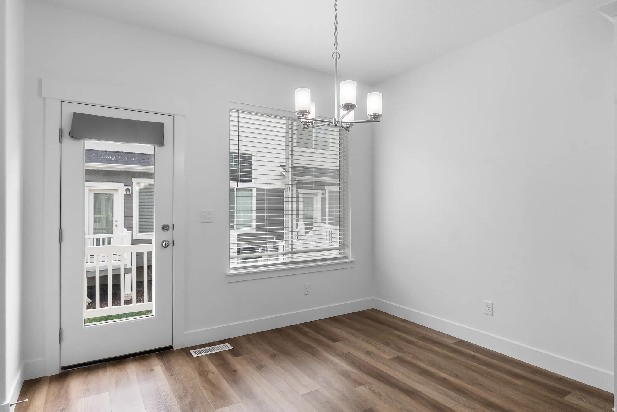 Unfurnished dining area featuring suspended lighting and wood finished floors