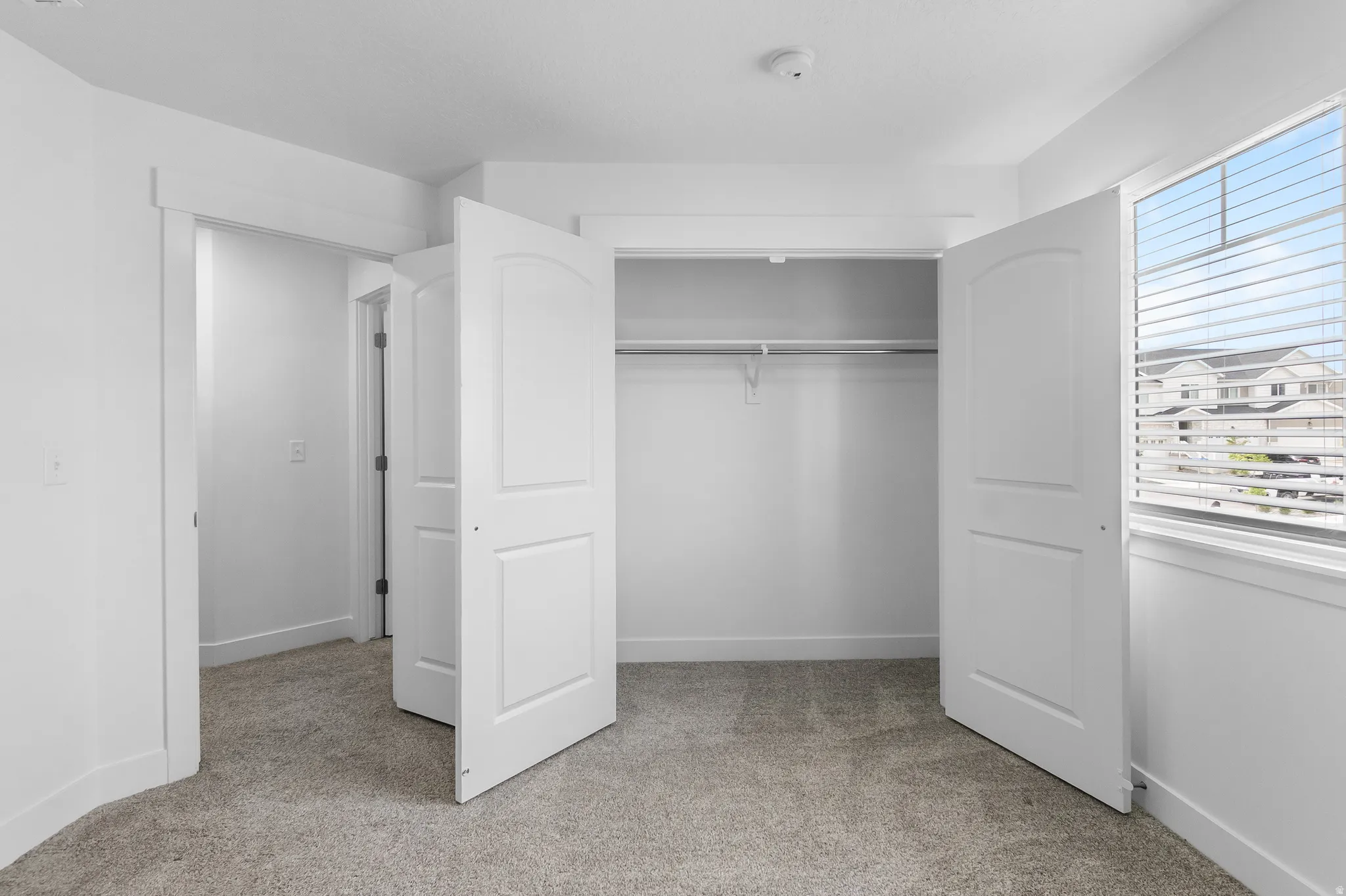 Unfurnished bedroom featuring light colored carpet and a closet