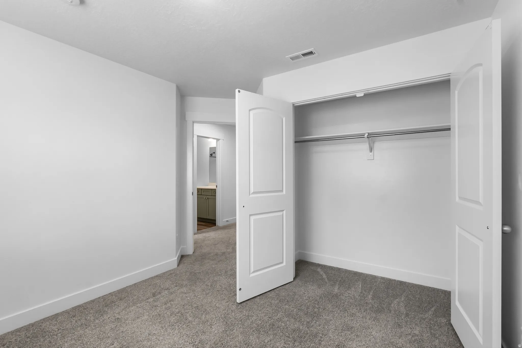 Unfurnished bedroom with dark colored carpet and a closet