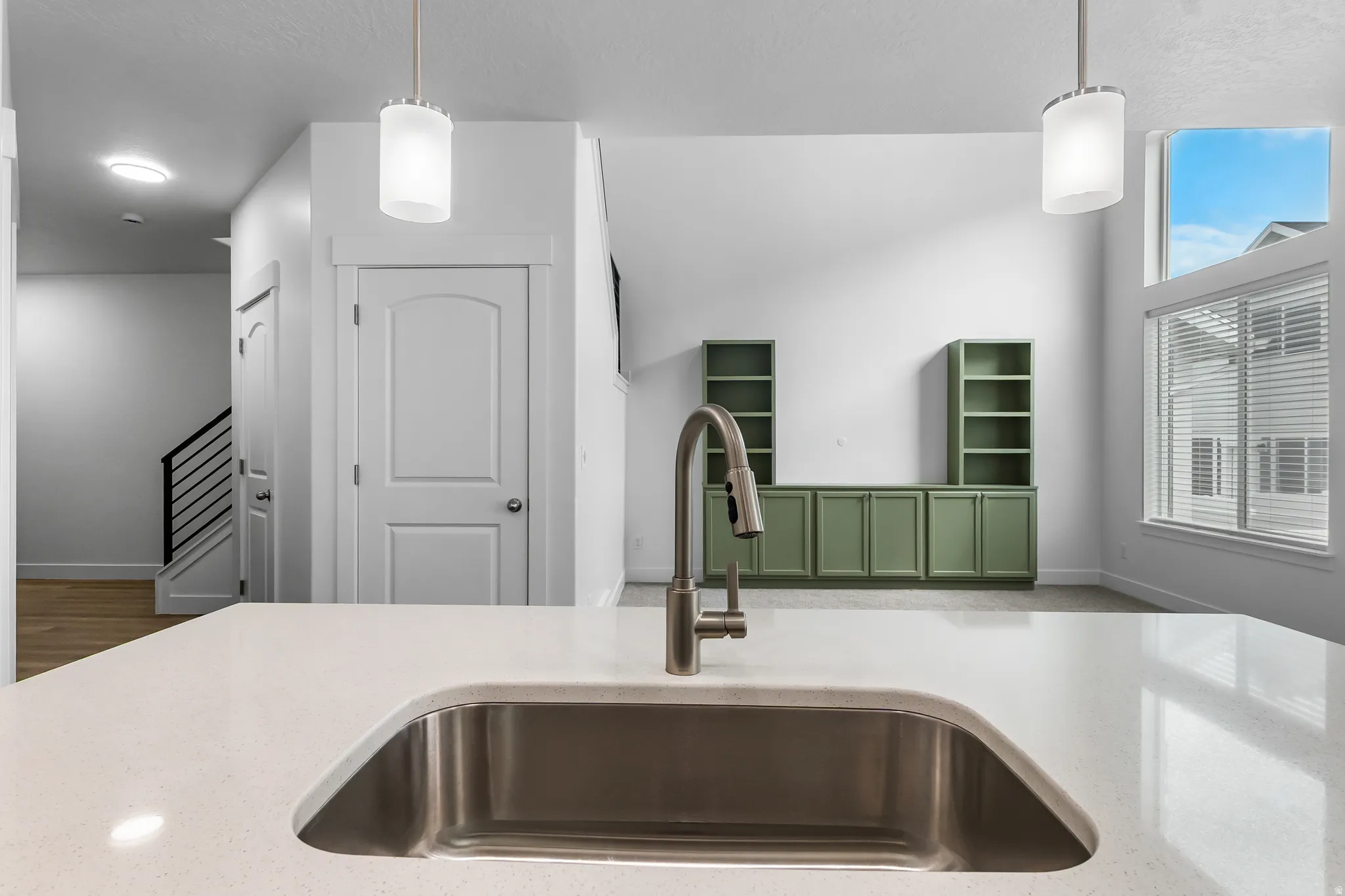Kitchen with light stone counters and decorative light fixtures