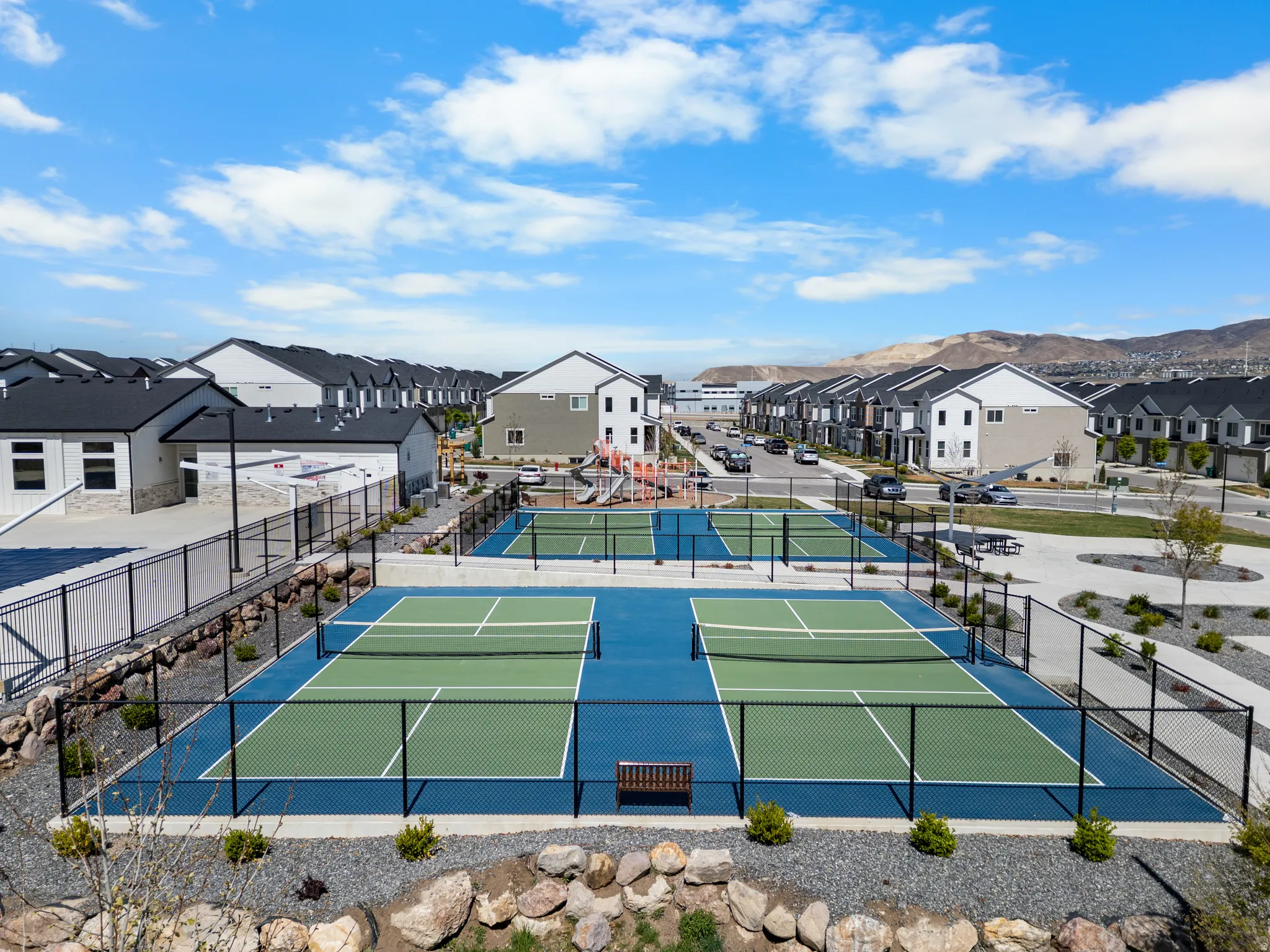 View of tennis court with a residential view