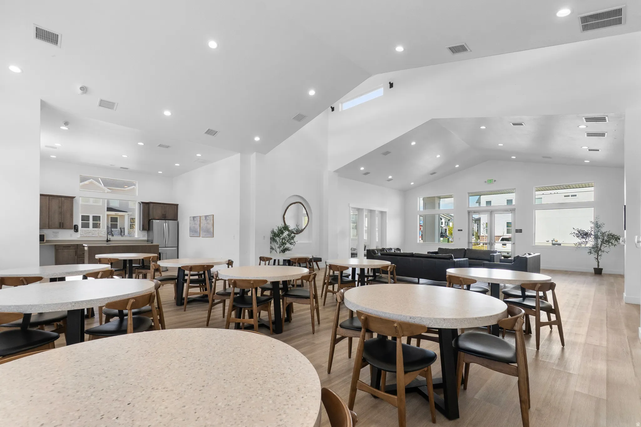 Dining space featuring light wood-style floors, a high ceiling, and recessed lighting