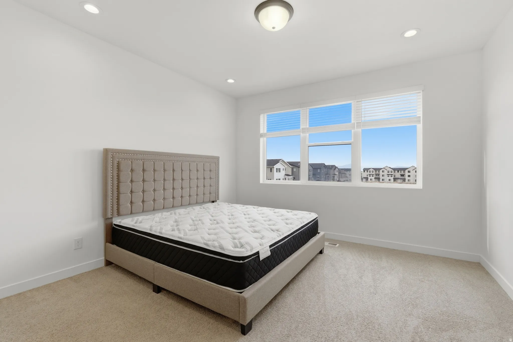 Bedroom featuring light carpet and recessed lighting