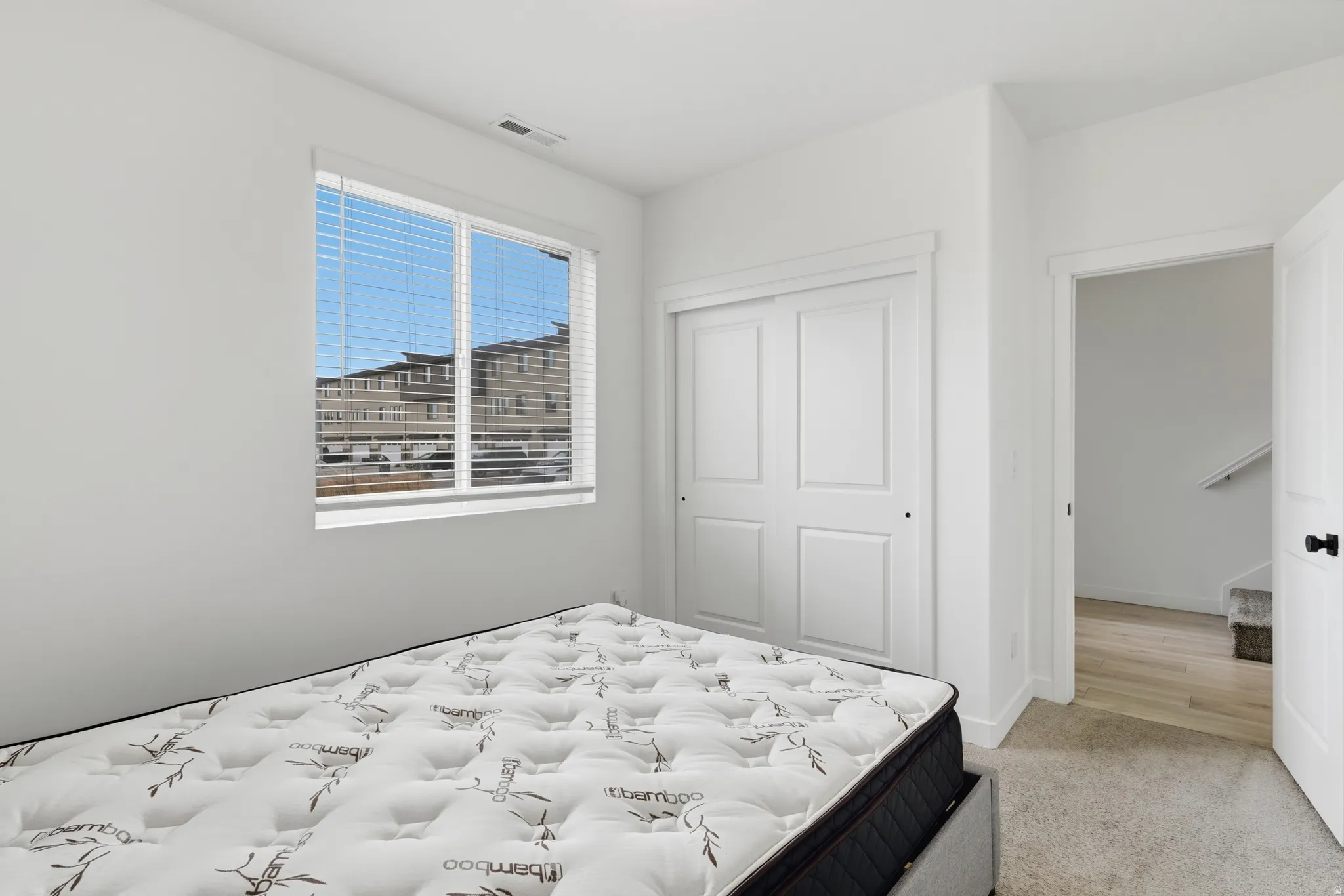 Bedroom featuring light colored carpet and a closet