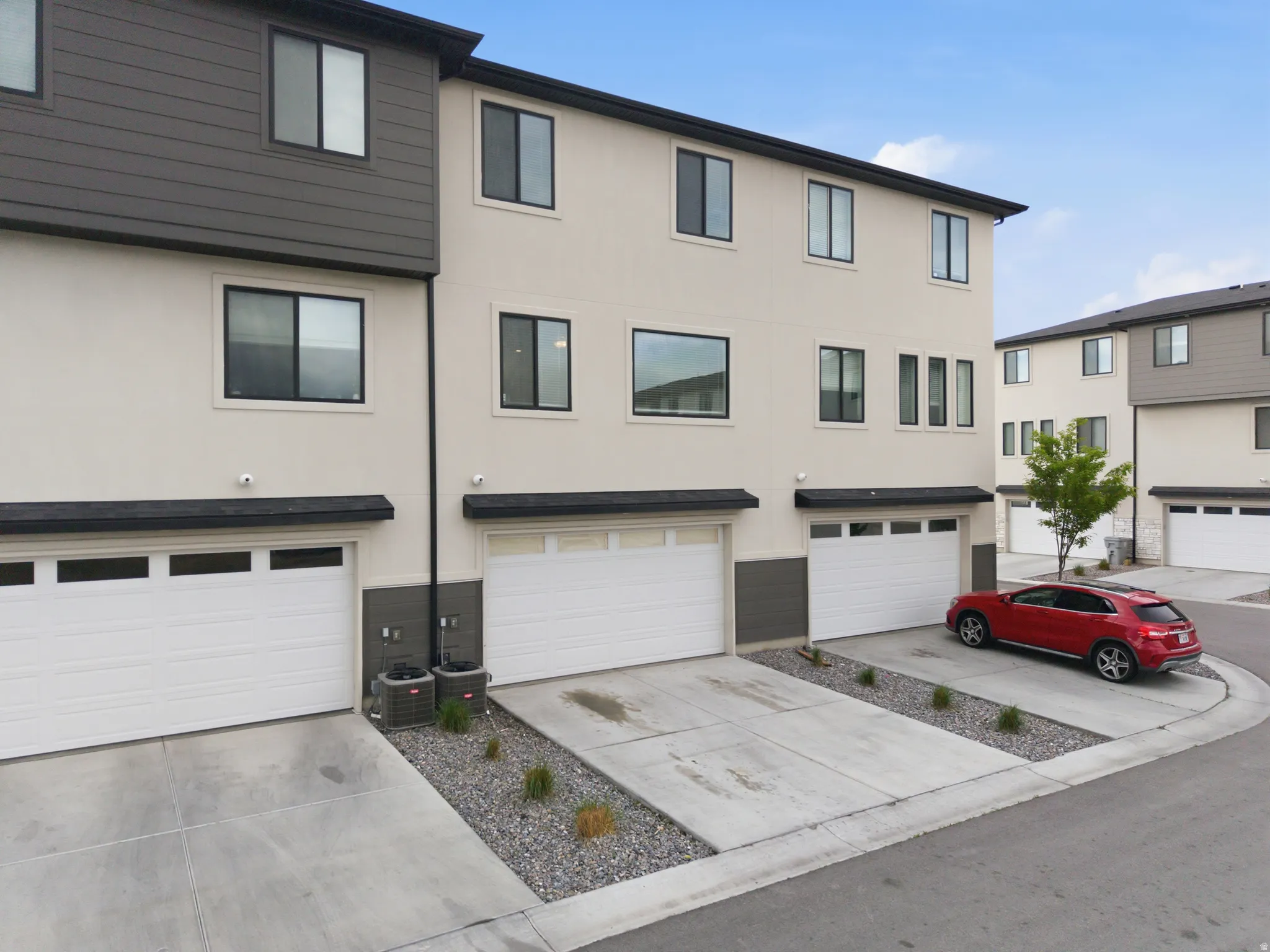Traditional-style house featuring stucco siding, an attached garage, and driveway
