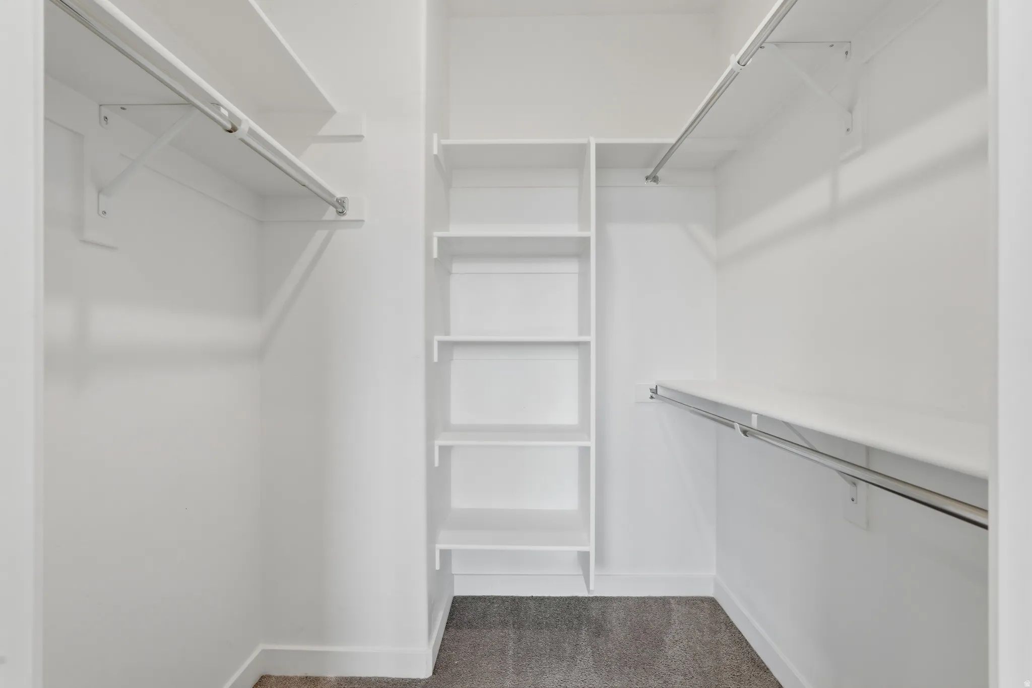 Walk in closet with dark colored carpet