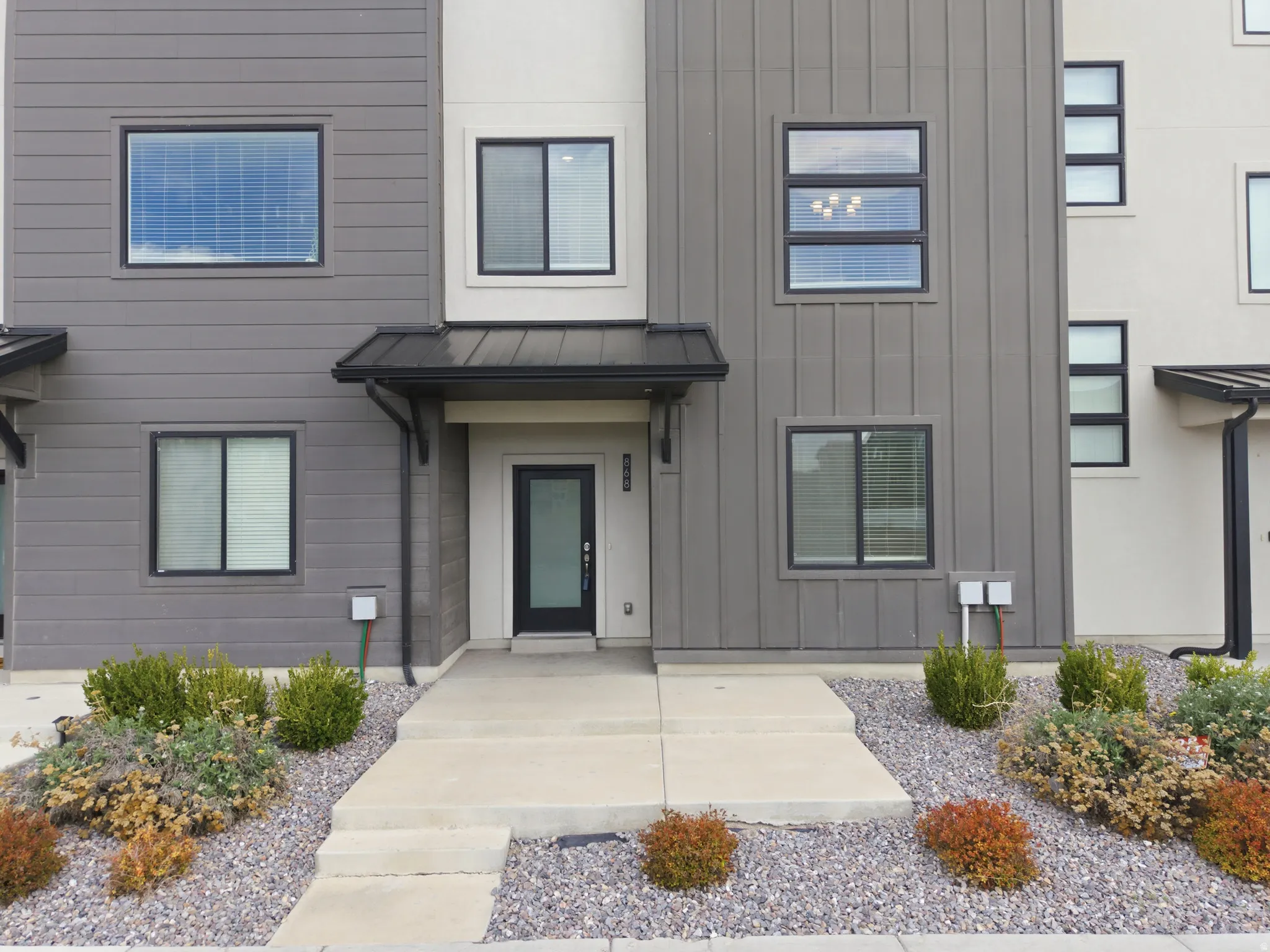 View of front facade featuring board and batten siding and a standing seam roof