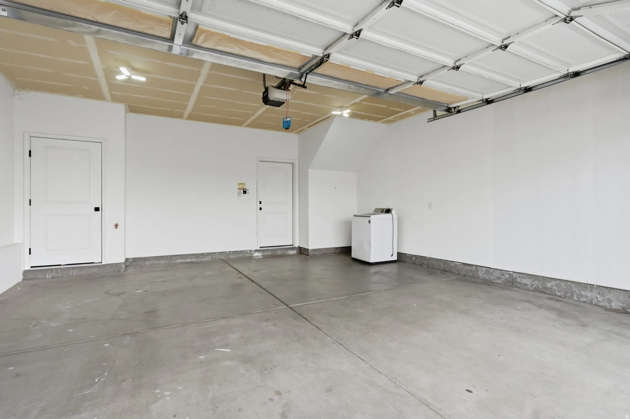 Garage featuring washer / dryer and a garage door opener