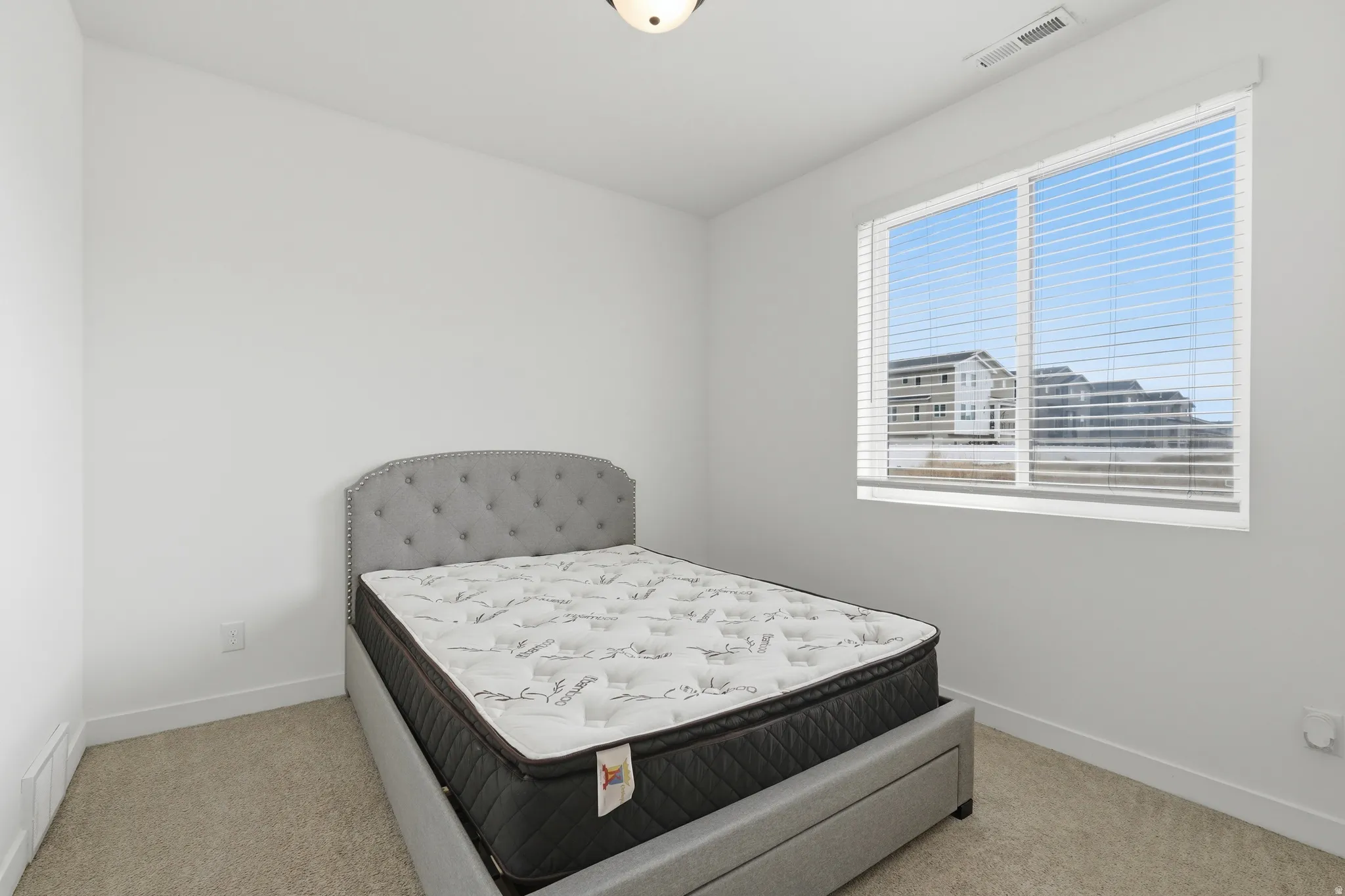 Bedroom featuring light carpet