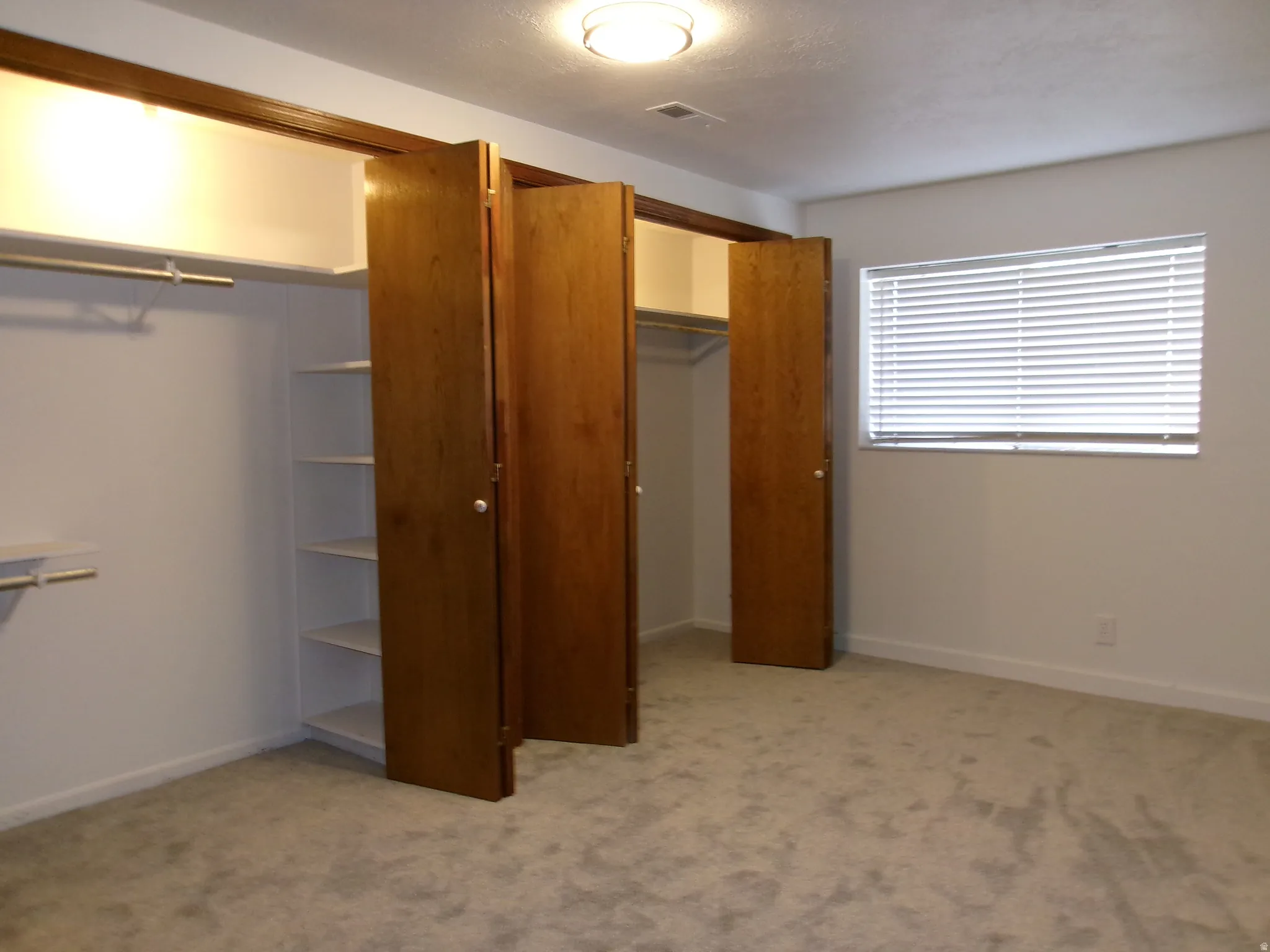 Large basement bedroom with light colored carpet and a closet 9 x 14