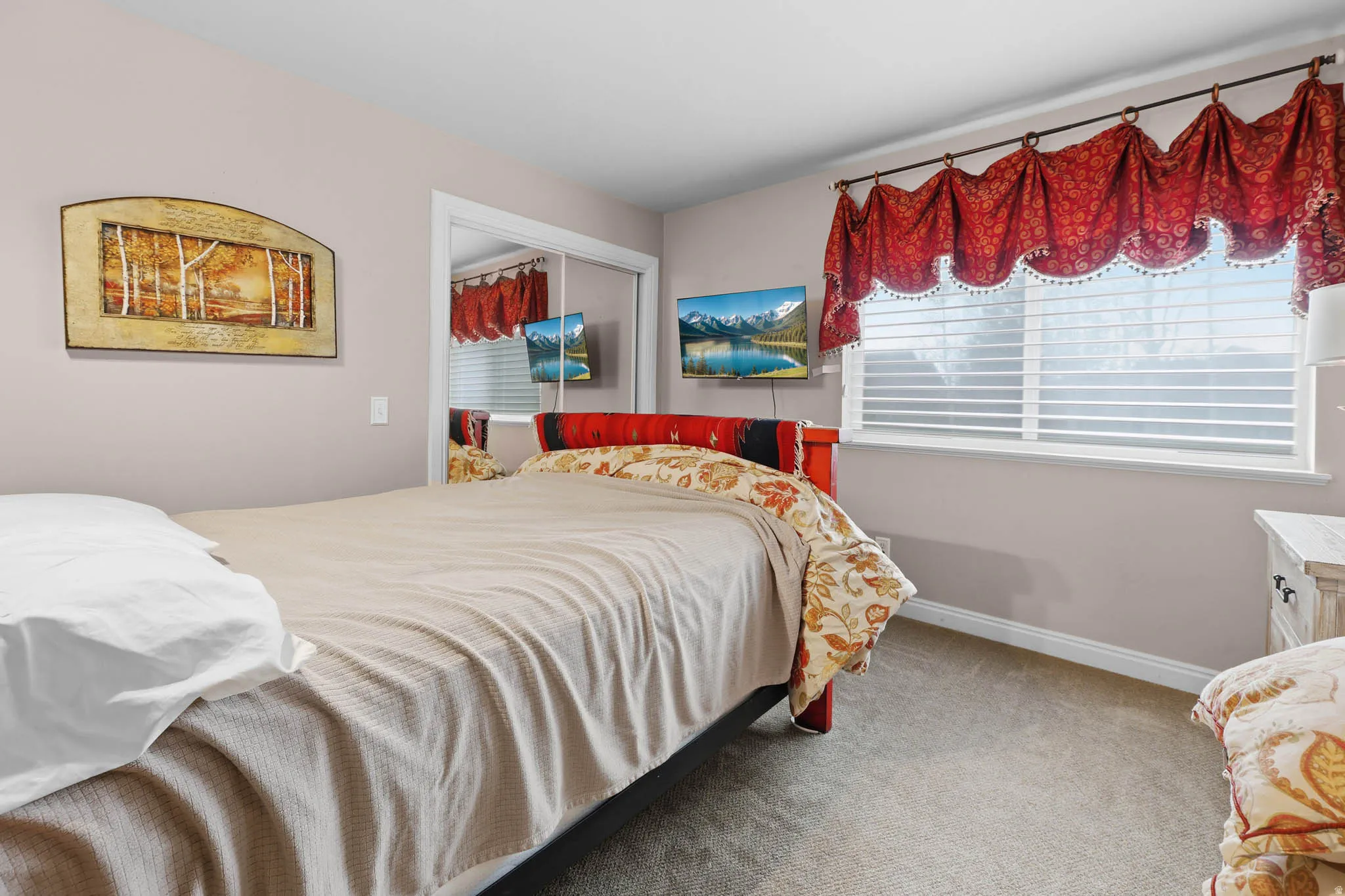 Carpeted bedroom featuring a closet and baseboards
