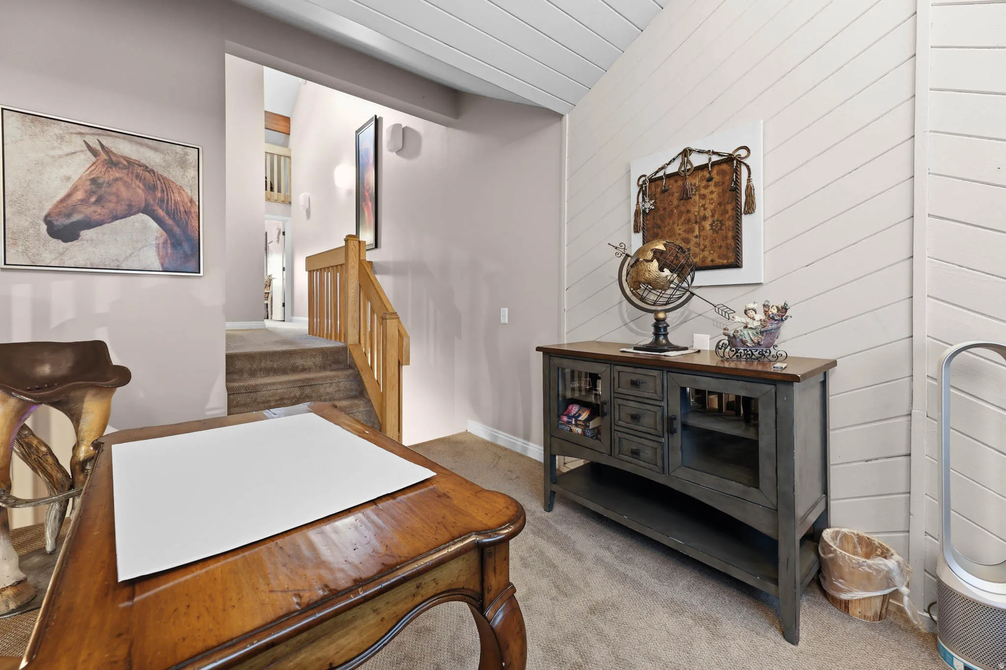 Office area featuring light colored carpet and wooden walls