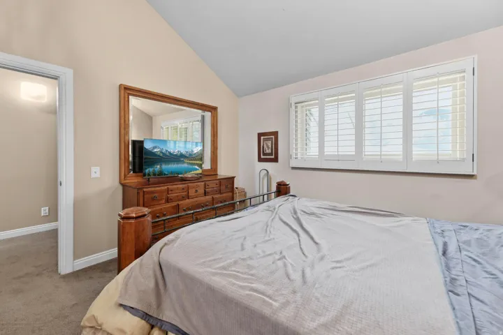 Bedroom featuring carpet floors and lofted ceiling