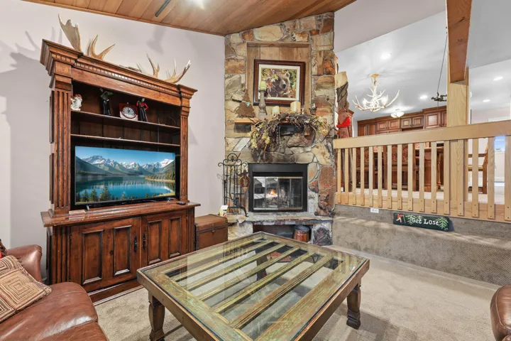Carpeted living room with a vaulted wood ceiling, a fireplace, and recessed lighting