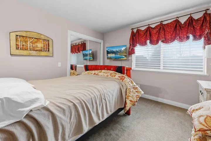 Carpeted bedroom featuring a closet and baseboards