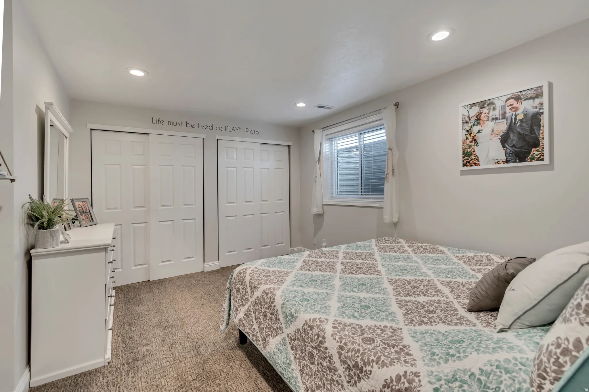 Carpeted bedroom featuring two closets and recessed lighting