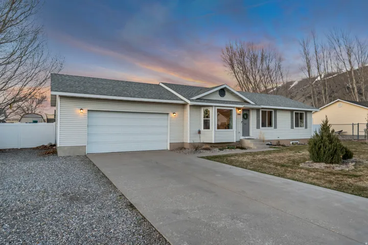 Ranch-style house with driveway, a shingled roof, and a garage