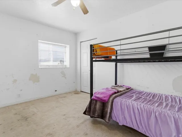 Bedroom featuring light carpet and a ceiling fan