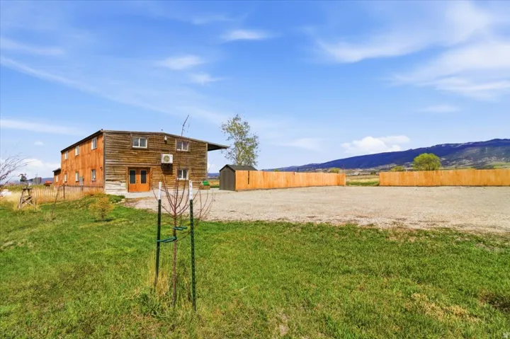 Rear view of property with an outdoor structure and a mountain view
