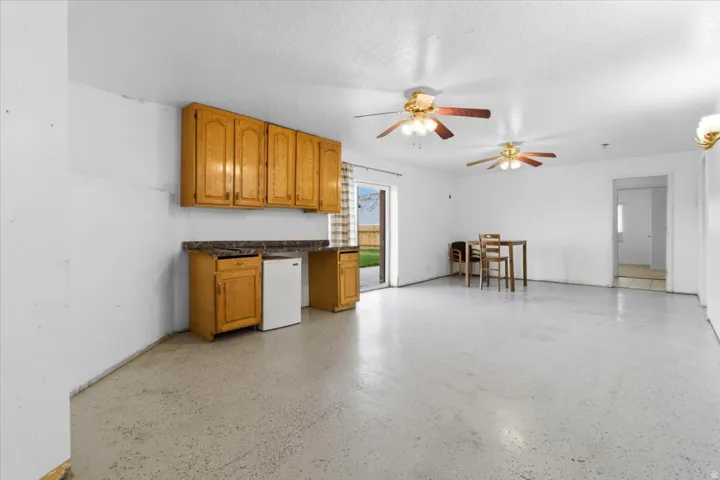 Kitchen featuring wood finish cabinets, a ceiling fan, and a textured ceiling
