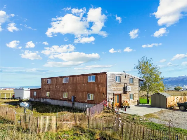 Back of property with a patio, a mountain view, and a storage unit